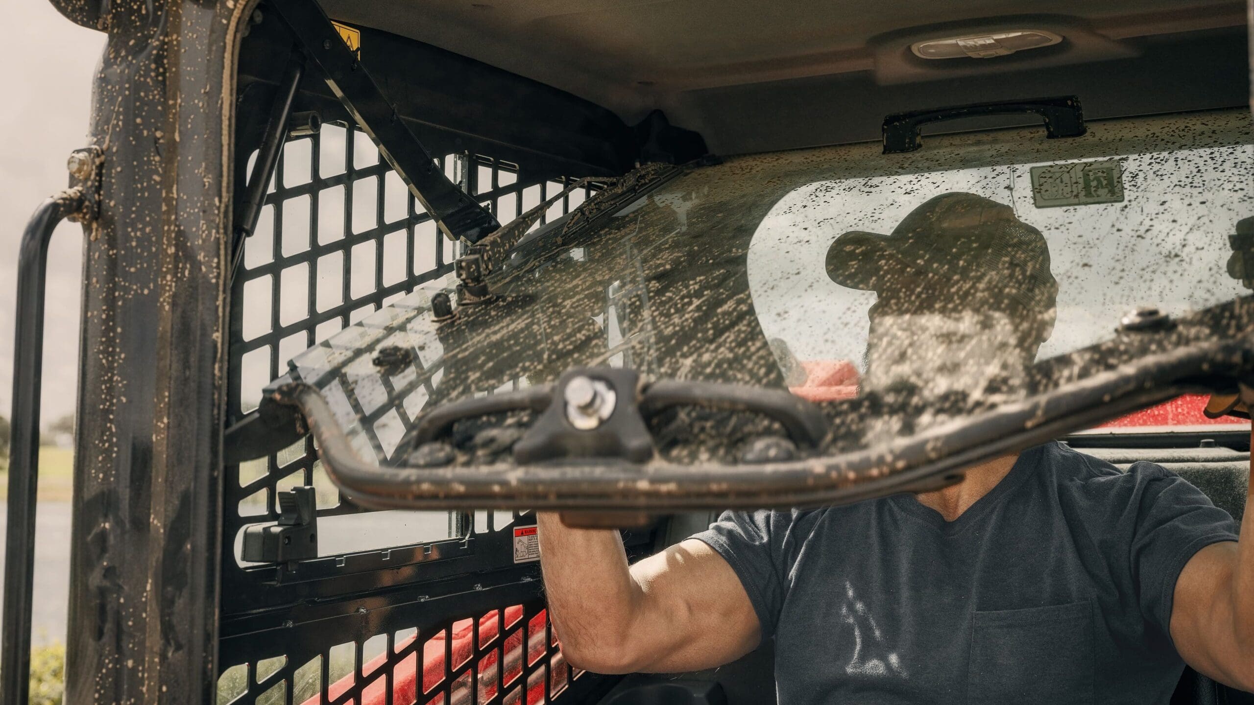 Opening the cab door on a skid steer loader